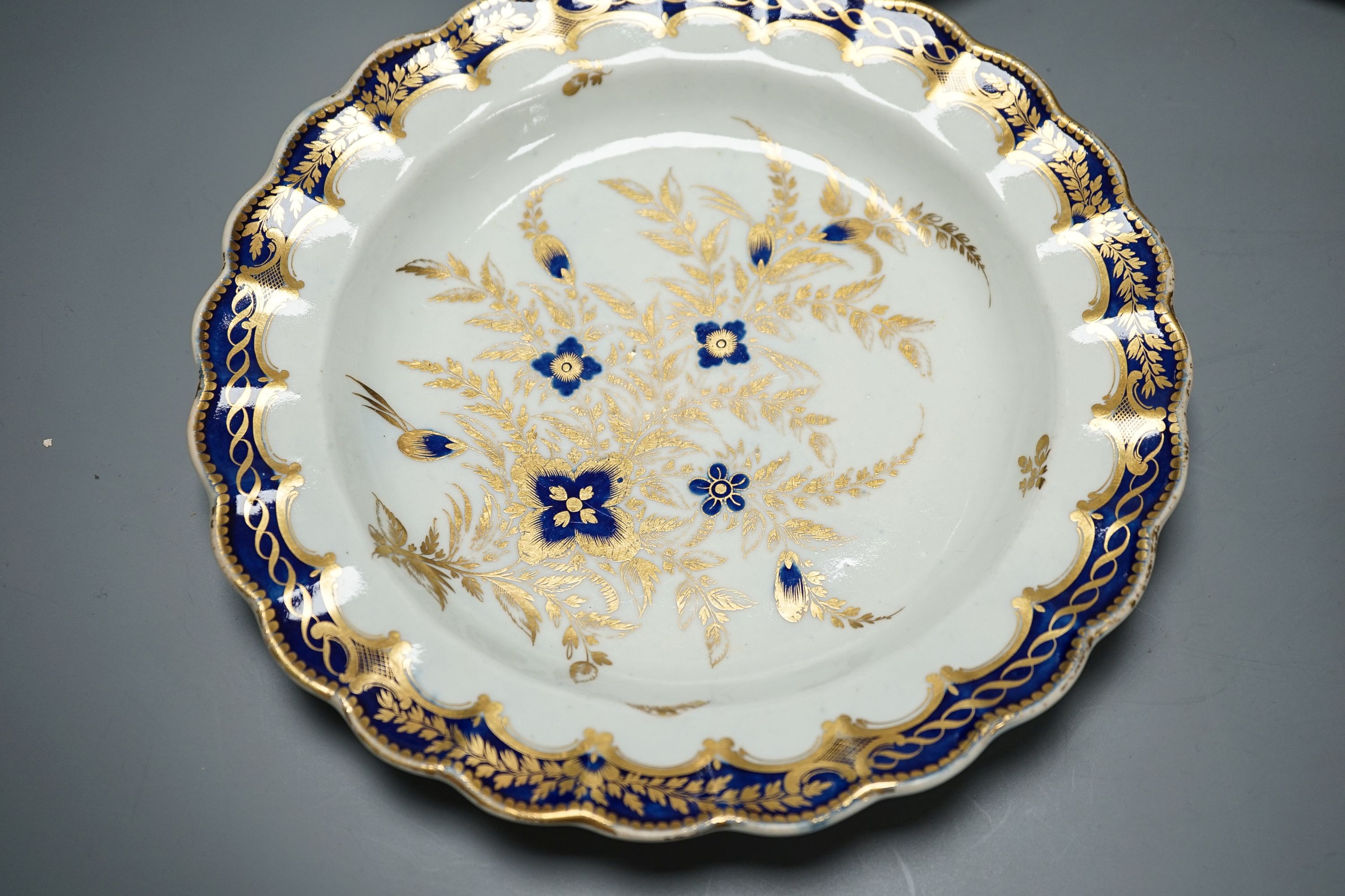 18th/19th century cabinet plates - A rare early Coalport landscape dessert plate, c.1805-10, a Coalport style plate, a Worcester blue and gilt foliate dish, c. 1790 and a pair of Royal Worcester dishes (5)